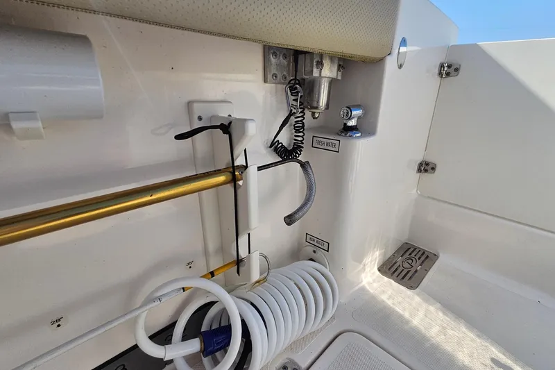 Slide: The Image of 2018 Pursuit DC 295 Dual Console boat interior with fresh and raw water outlets. - 18