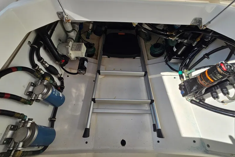 Slide: The Image of 2018 Pursuit DC 295 Dual Console engine compartment with ladder and mechanical components. - 19