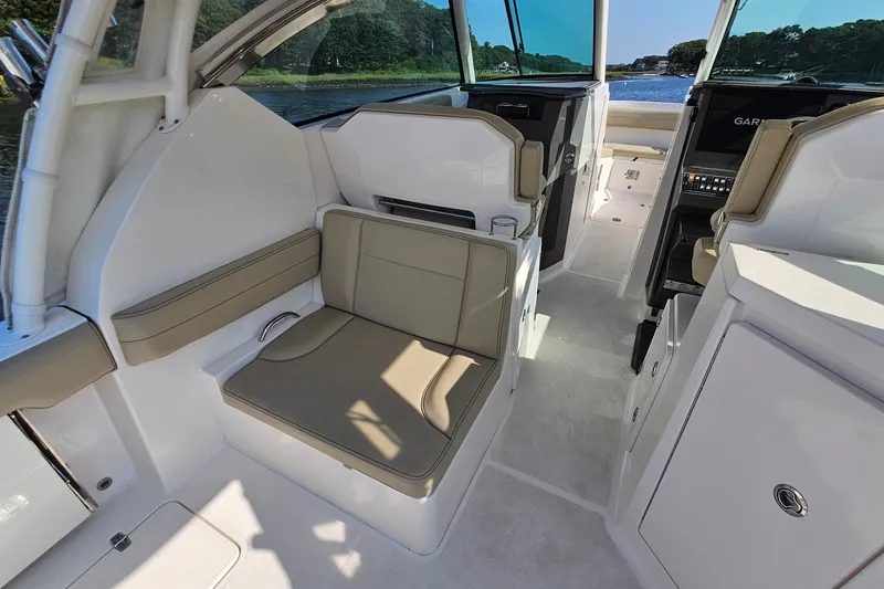 Slide: The Image of 2018 Pursuit DC 295 Dual Console interior with beige seating and modern dashboard. - 22