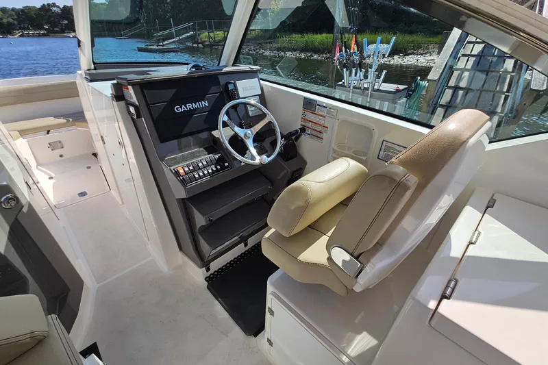 Slide: The Image of 2018 Pursuit DC 295 Dual Console boat interior with Garmin navigation system and comfortable seating. - 27