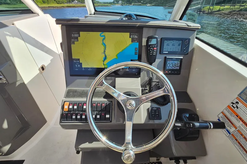 Slide: The Image of 2018 Pursuit DC 295 Dual Console boat dashboard with navigation and control systems. - 29