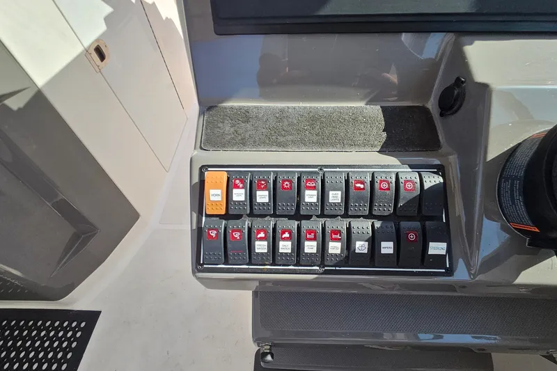 Slide: The Image of Control panel of a 2018 Pursuit DC 295 Dual Console boat with labeled switches. - 32