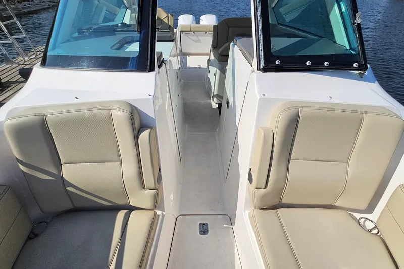 Slide: The Image of 2018 Pursuit DC 295 Dual Console boat interior with beige seating and windshield. - 37
