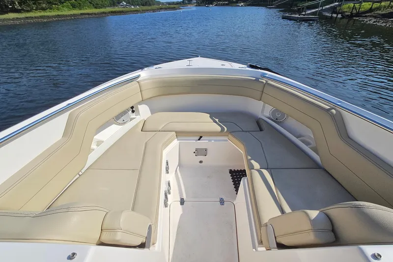 Slide: The Image of 2018 Pursuit DC 295 Dual Console boat interior with beige seating on calm water. - 38