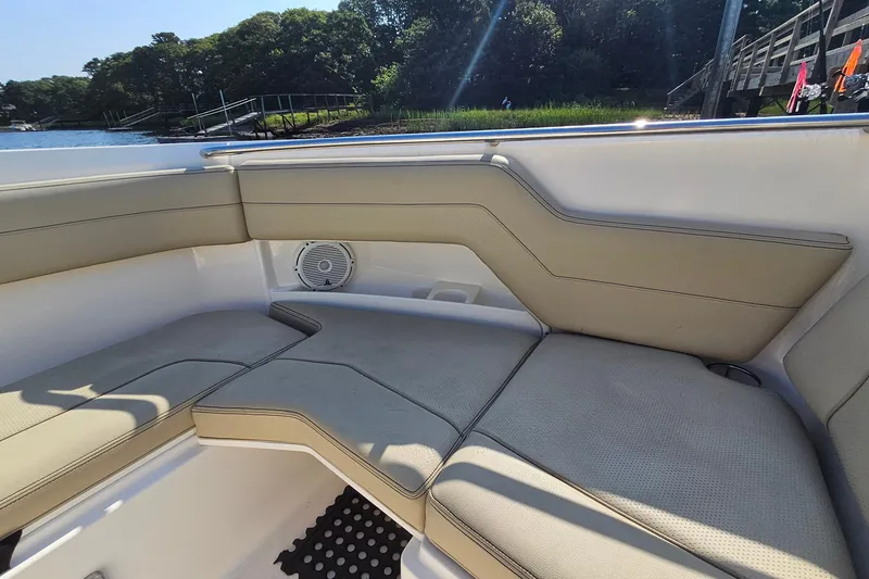 Slide: The Image of 2018 Pursuit DC 295 Dual Console boat interior with beige seating and speaker. - 39