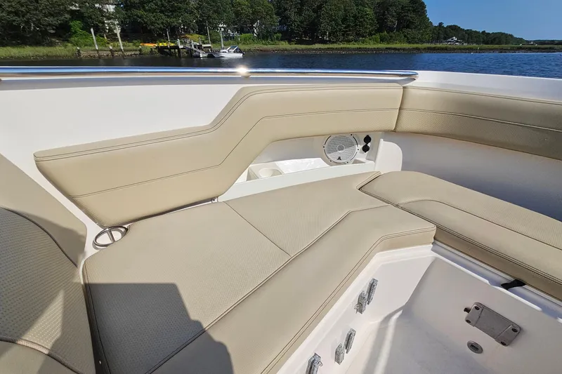 Slide: The Image of 2018 Pursuit DC 295 Dual Console boat interior with beige seating and speaker. - 40