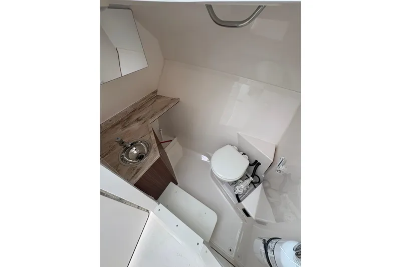 Slide: The Image of 2018 Pursuit DC 295 Dual Console boat interior with sink and toilet. - 42