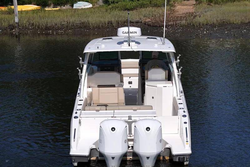 Slide: The Image of 2018 Pursuit DC 295 Dual Console boat on water, rear view with twin engines. - 5