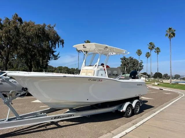 Slide: The Image of 2018 Sea Fox 248 Commander boat on trailer, parked near palm trees. - 0