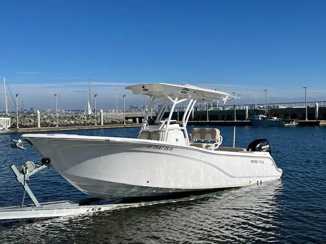 Slide: The Image of 2018 Sea Fox 248 Commander boat docked in a marina under clear blue skies. - 1