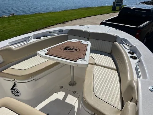 Slide: The Image of 2018 Sea Fox 248 Commander boat interior with seating and table, near water. - 25