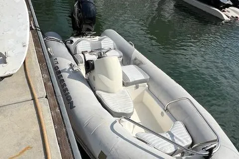 Slide: The Image of Inflatable boat docked beside a pier, featuring cushioned seating and an outboard motor. - 25