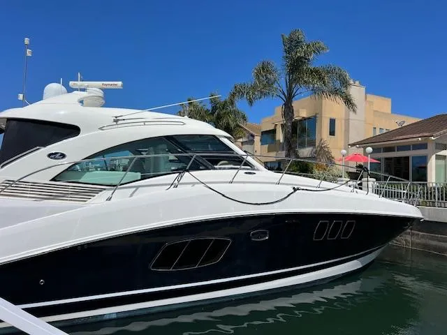 Slide: The Image of 2008 Sea Ray 55 Sundancer yacht docked near waterfront homes and palm trees. - 3