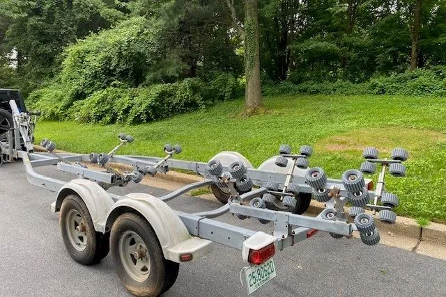 Slide: The Image of Trailer for 2008 Parker 2310 Walkaround boat parked on a road near greenery. - 15