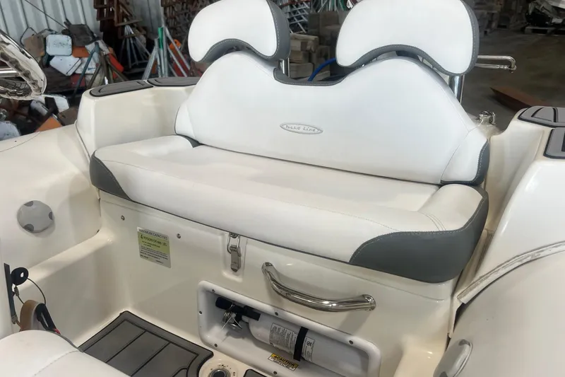 Slide: The Image of 2021 Zodiac Yachtline 360 boat seat with white and gray upholstery in a storage area. - 6