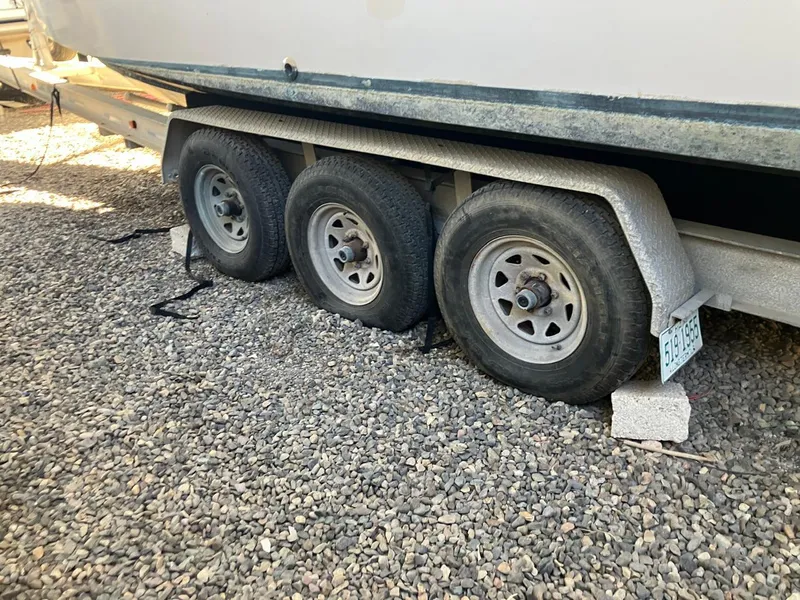 Slide: The Image of 2006 Grady-White Bimini 306 boat trailer with triple axles on gravel. - 16