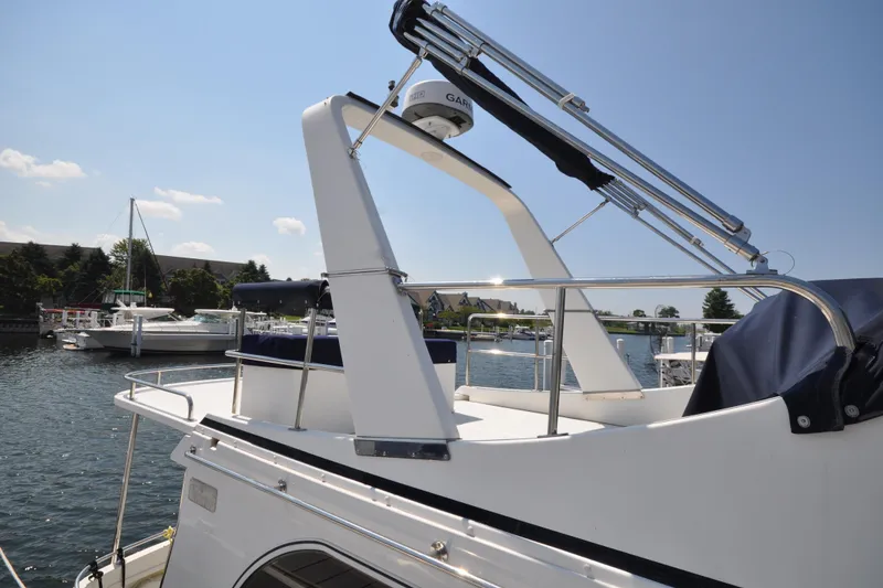 Slide: The Image of 2015 Helmsman Trawlers 31 Sedan boat docked in a marina under clear skies. - 10