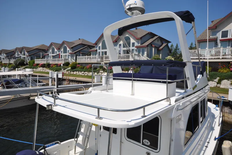 Slide: The Image of 2015 Helmsman Trawlers 31 Sedan docked near waterfront homes. - 12