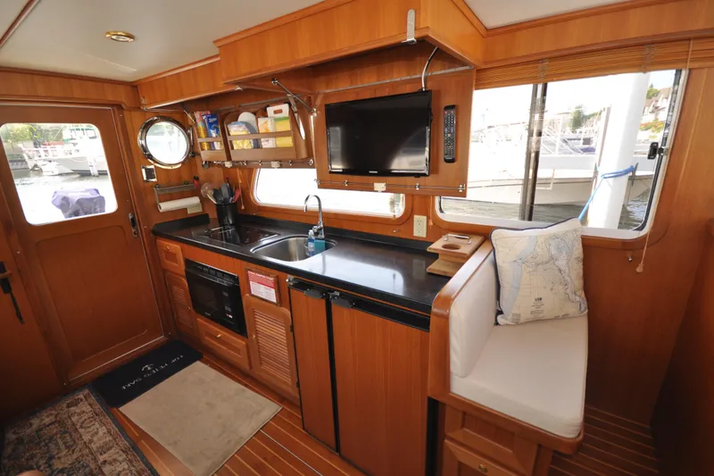 Slide: The Image of 2015 Helmsman Trawlers 31 Sedan interior with kitchen and seating area. - 14