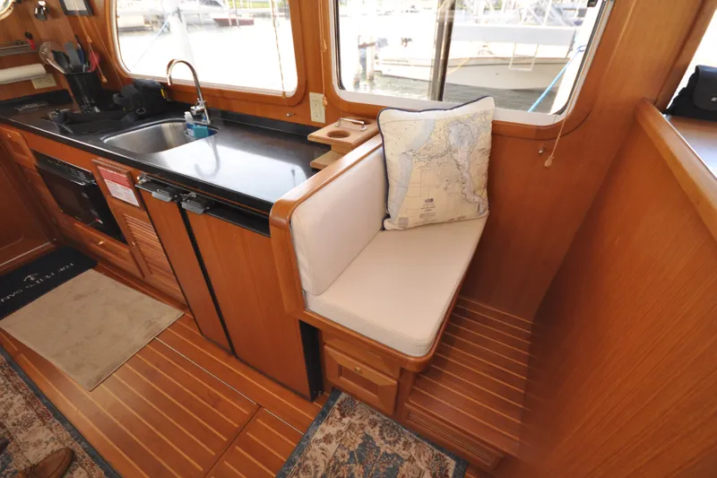 Slide: The Image of 2015 Helmsman Trawlers 31 Sedan interior with kitchen and seating area. - 15