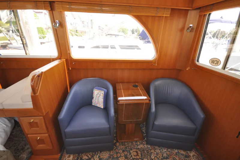 Slide: The Image of Interior of 2015 Helmsman Trawlers 31 Sedan with blue chairs and wooden accents. - 21