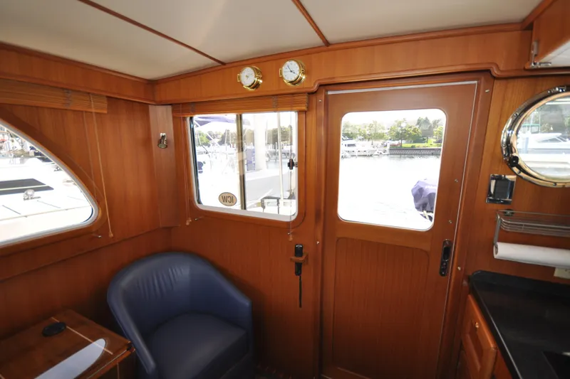 Slide: The Image of Interior of 2015 Helmsman Trawlers 31 Sedan with wood paneling and blue chair. - 22