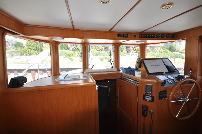 Slide: The Image of Helmsman Trawlers 31 Sedan 2015 interior helm with navigation equipment and wooden finish. - 23