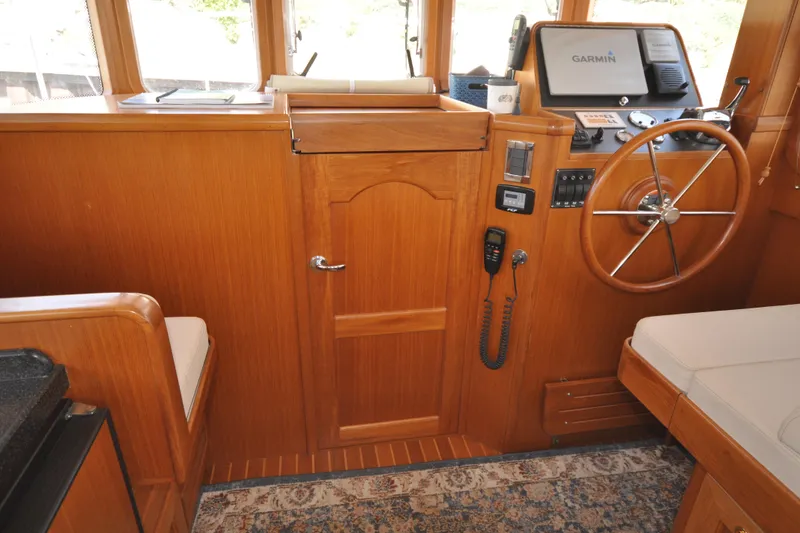 Slide: The Image of Helmsman Trawlers 31 Sedan 2015 interior with wooden helm, Garmin navigation, and seating. - 24