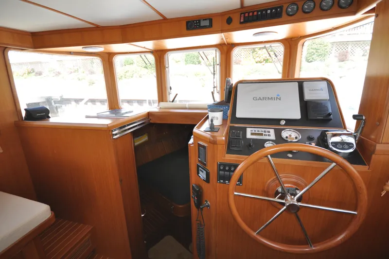 Slide: The Image of Helmsman Trawlers 31 Sedan 2015 helm with Garmin navigation system and wooden steering wheel. - 25