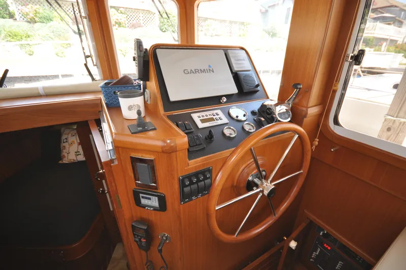 Slide: The Image of Helmsman Trawlers 31 Sedan 2015 helm with Garmin navigation system and wooden steering wheel. - 26