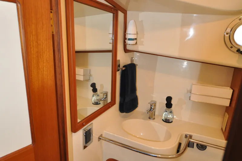 Slide: The Image of 2015 Helmsman Trawlers 31 Sedan bathroom with mirror, sink, and porthole. - 38