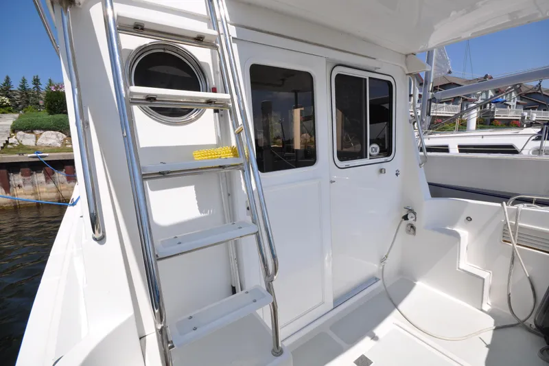 Slide: The Image of 2015 Helmsman Trawlers 31 Sedan boat deck with ladder and cabin door. - 4