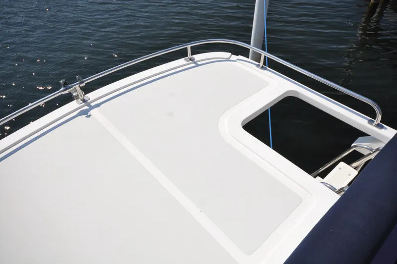 Slide: The Image of 2015 Helmsman Trawlers 31 Sedan boat deck with railing on water. - 54
