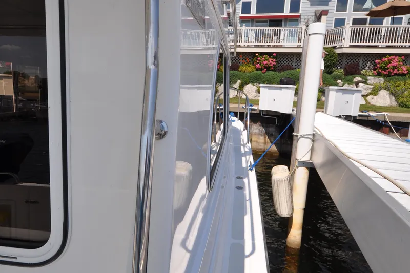Slide: The Image of 2015 Helmsman Trawlers 31 Sedan docked, side view with marina background. - 6