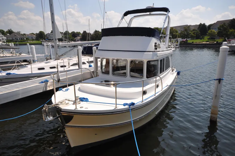 Slide: The Image of 2015 Helmsman Trawlers 31 Sedan docked at marina, sunny day. - 64