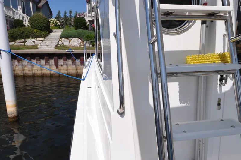 Slide: The Image of 2015 Helmsman Trawlers 31 Sedan docked, showing side view with ladder and mooring line. - 7