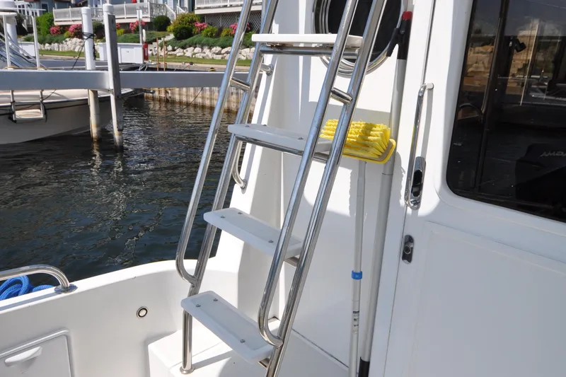 Slide: The Image of Stainless steel ladder on 2015 Helmsman Trawlers 31 Sedan boat docked by water. - 8