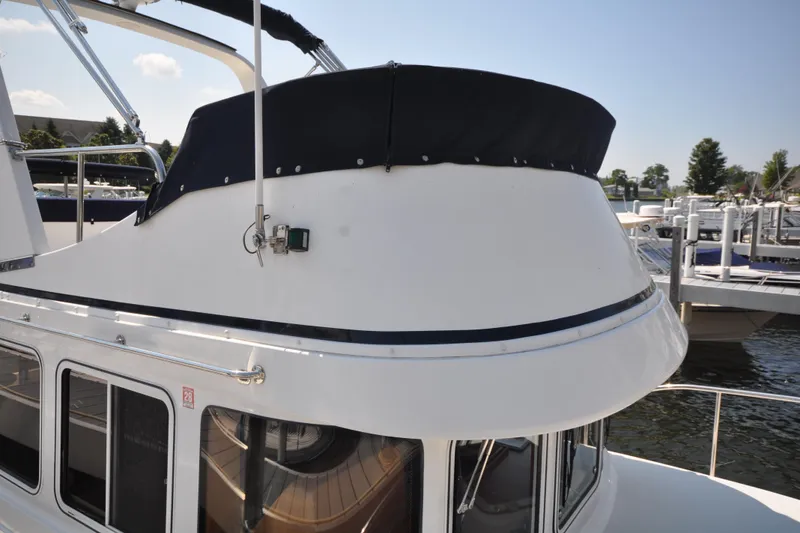 Slide: The Image of 2015 Helmsman Trawlers 31 Sedan boat docked at marina, featuring upper deck details. - 9