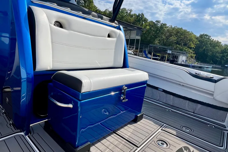 Slide: The Image of 2020 Nor-Tech 340 Sport Center Console interior with blue and white seating, dockside view. - 10