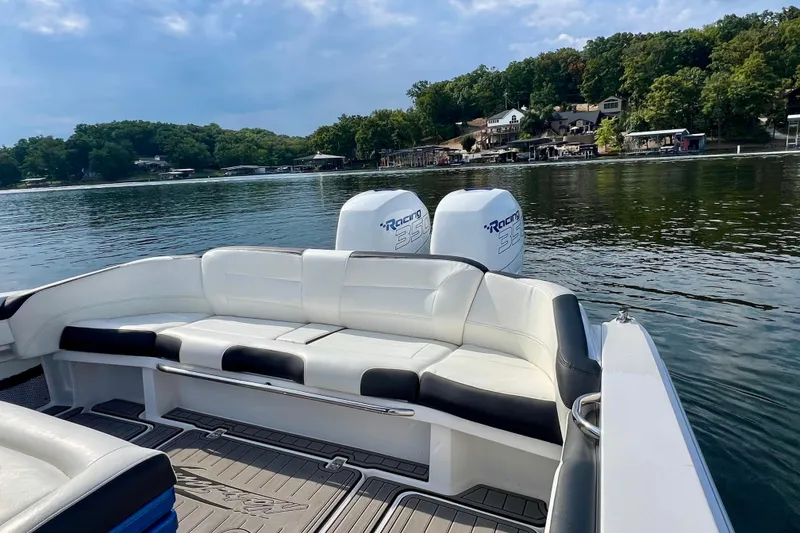 Slide: The Image of 2020 Nor-Tech 340 Sport Center Console boat with white seating, on a serene lake. - 11