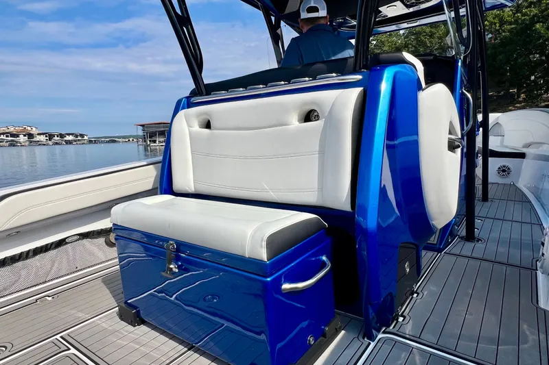 Slide: The Image of 2020 Nor-Tech 340 Sport Center Console boat with blue and white seating on a sunny day. - 15
