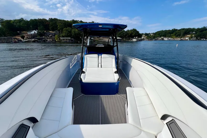 Slide: The Image of 2020 Nor-Tech 340 Sport Center Console boat on a serene lake with lush shoreline. - 19