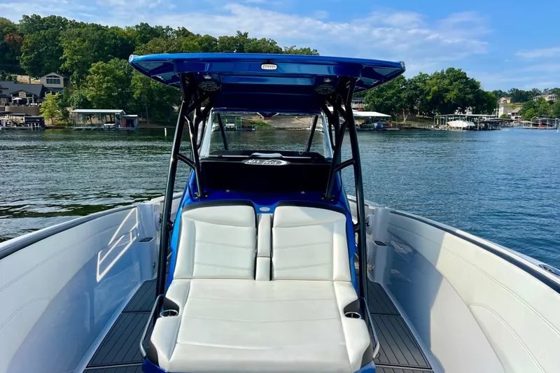 Slide: The Image of 2020 Nor-Tech 340 Sport Center Console boat on a serene lake with lush greenery. - 20