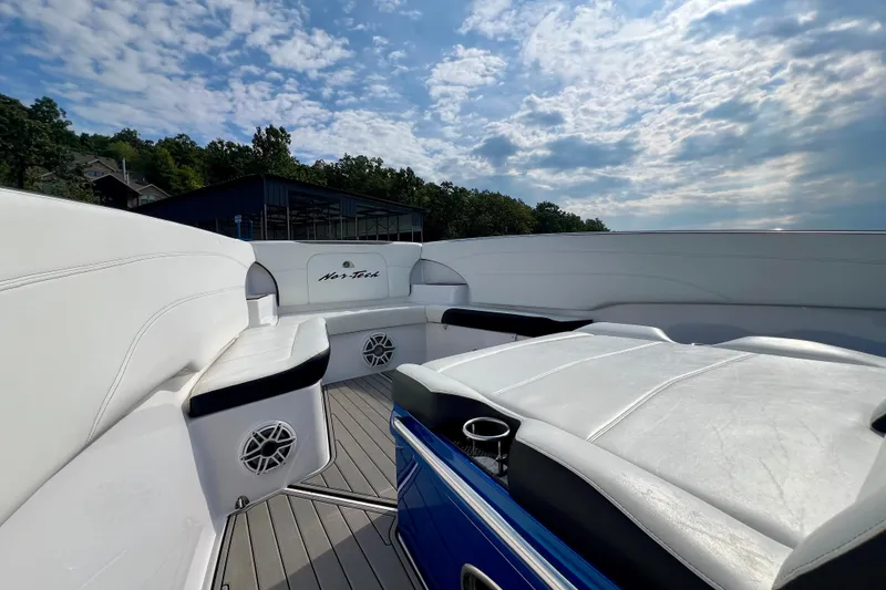 Slide: The Image of 2020 Nor-Tech 340 Sport Center Console boat interior with white seating and blue accents. - 23