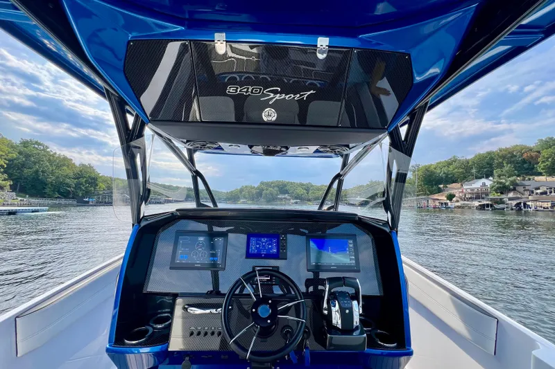Slide: The Image of 2020 Nor-Tech 340 Sport Center Console boat dashboard with scenic lake view. - 25