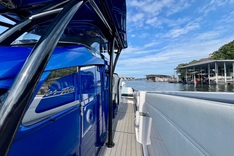 Slide: The Image of 2020 Nor-Tech 340 Sport Center Console boat docked by a scenic waterfront. - 26