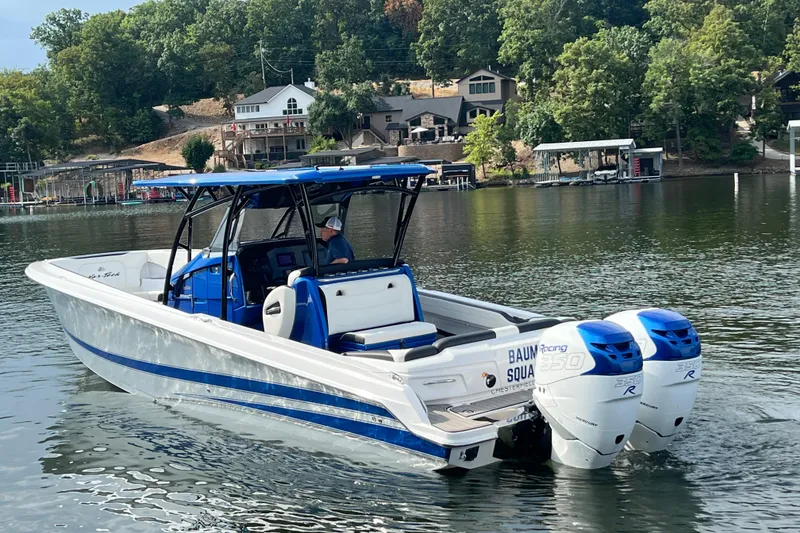 Slide: The Image of 2020 Nor-Tech 340 Sport Center Console boat on a scenic lake with trees and houses. - 5