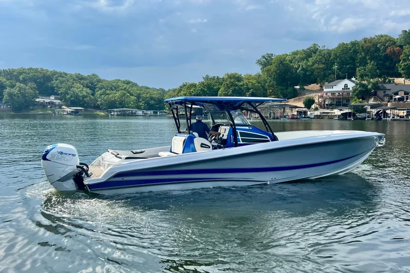 Slide: The Image of 2020 Nor-Tech 340 Sport Center Console boat cruising on a scenic lake. - 7