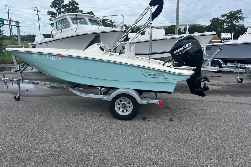 Slide: The Image of 2021 Boston Whaler 130 Super Sport boat on trailer with Mercury outboard motor. - 1