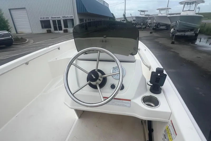 Slide: The Image of 2021 Boston Whaler 130 Super Sport boat dashboard with steering wheel and controls. - 10